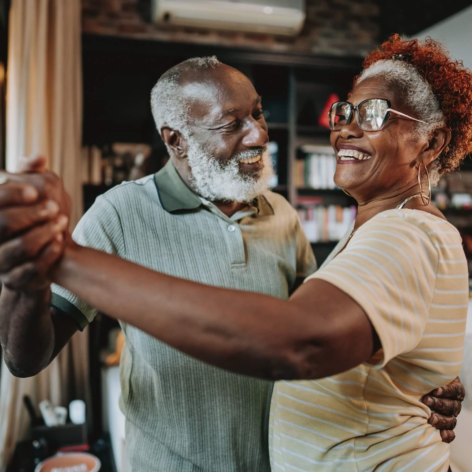 Mature african-american couple holding hands while dancing